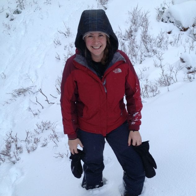 Ahna Van Gaest standing in the snow and smiling up at the camera.