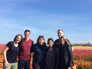group of men and women pose in front of tulip field
