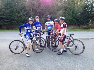 6 members of the WWU cycle team pose in a semi-circle straddling their bikes