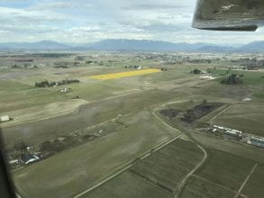 aerial photo of wide valley with green and yellow fields
