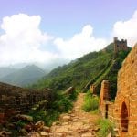 Great Wall of China stretches through green hilly landscape