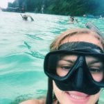 Student wearing snorkel mask in tropical water