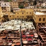 Circular pools of fabric dye sit in the middle of an ancient city