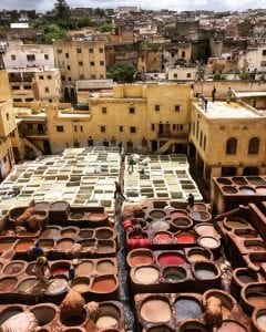 Circular pools of fabric dye sit in the middle of an ancient city