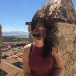 Wind catches a student's hair over a Mediterranean town