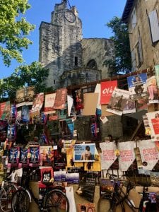 Various French posters shown hanging on a fence, with historical brick buildings behind