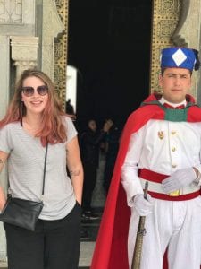Student poses with a guard wearing traditional clothes