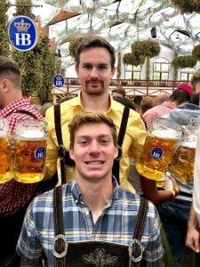 Students hold beers at a German brewpub