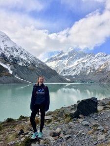 Student posing in front of mountains and lake