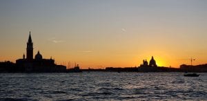 A sunset over silhouettes of classical buildings