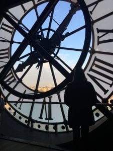 Student looks over a city from the interior of a clock tower
