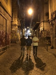Three students walk down a graffiti-lined street