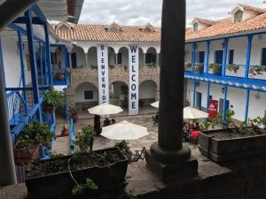 A courtyard of a hotel, with terracotta roof and a large banner reading "Welcome"