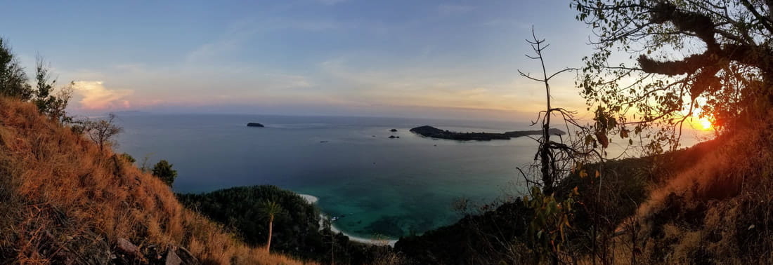 A view over the water of from the top of Adang Island at sunset.